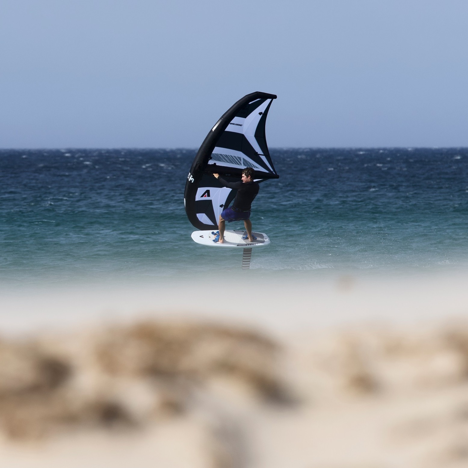 Pratique du wingfoil avec la planche Armstrong Wing FG Board 2025 sur l’eau turquoise
