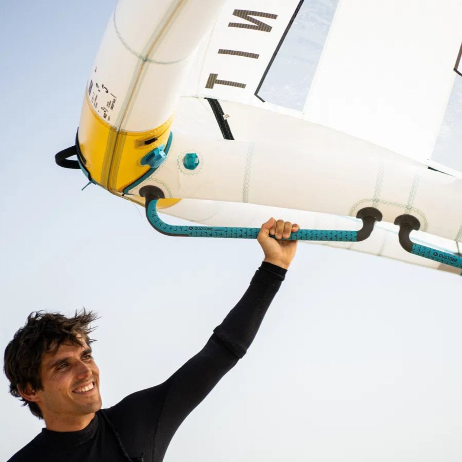 Rider tenant une aile de wingfoil Duotone équipée des poignées carbone Handle Fusion Set 2025