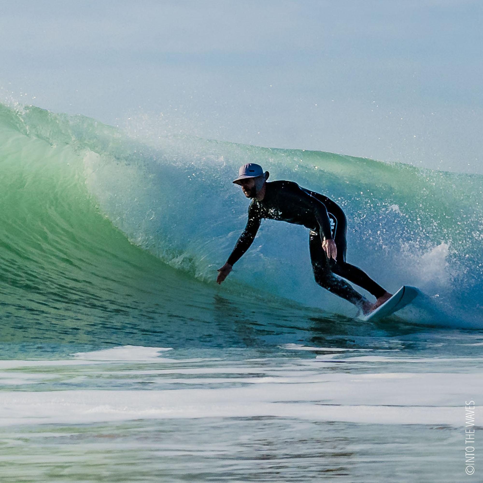 Surfeur casqué avec le WIP Surf Bob Bump Shell dans une vague creuse